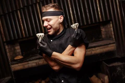 Cheerful chef posing with a serving of Khinkali. Georgian national traditional Stock Photos