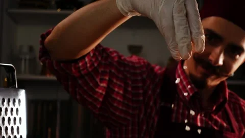 Cheerful chef in red uniform is throwing salt in process of preparing meal in a Video stock 151113652