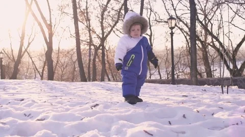 Cheerful child playing in the first snow in winter. Year old baby boy Stock Footage 70152532