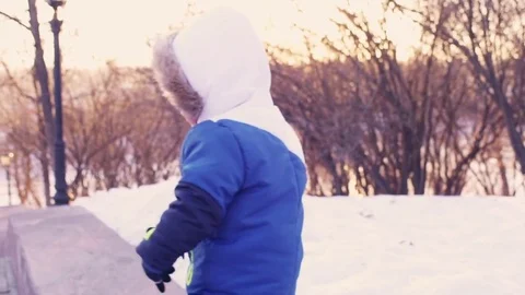 Cheerful child playing in the first snow in winter. Year old baby boy  Stock Footage 70152973