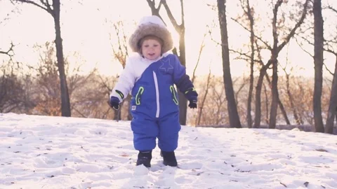 Cheerful child playing in the first snow in winter. Year old baby boy  Stock Footage 70153005