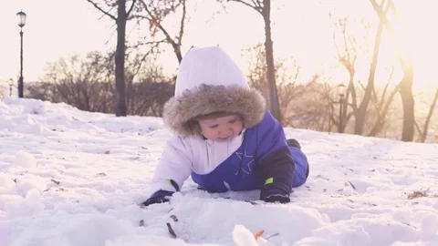Cheerful child playing in the first snow in winter. Year old baby boy  Stock Footage 70153031