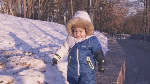 Cheerful child playing in the first snow in winter.  Stock Footage 70153405