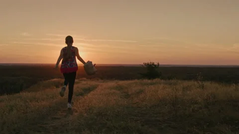 A cheerful child runs and waves his pack at sunset. Back to school concept Stock-Footage 136721632