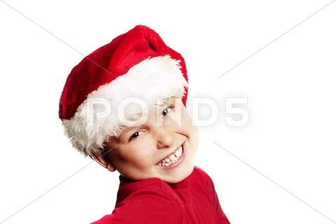 Cheerful child wearing a red Christmas hat Stock Photos
