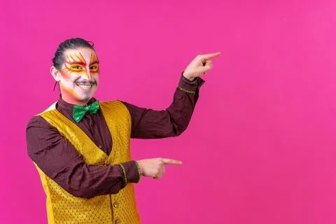 Cheerful circus performer pointing on an empty pink background for copyspace Stock Photos
