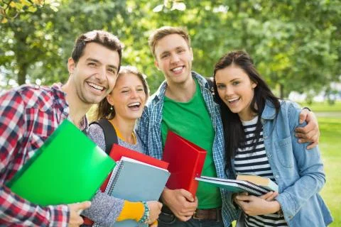 Cheerful college students with bags and books in park Stock Photos