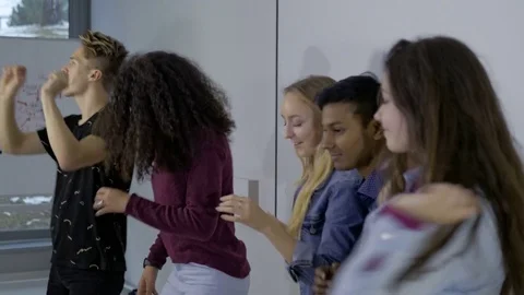 Cheerful college students dancing in the classroom Vídeo Stock 74617793
