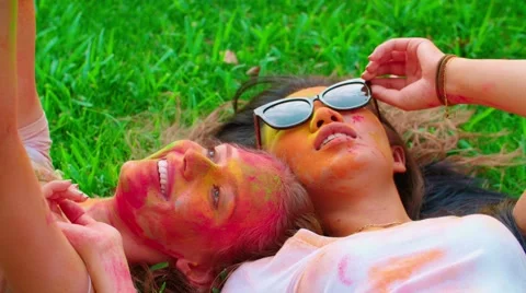 Cheerful company of young friends having fun in the Park with the colors of Holi Stock Footage