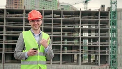 Cheerful construction supervisor posing for camera against new building Stock Photos