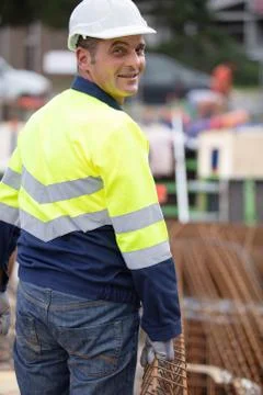 Cheerful construction worker pushing a wheelbarrow Stock Photos