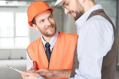 Cheerful constructor speaking with beaming ganger Stock Photos