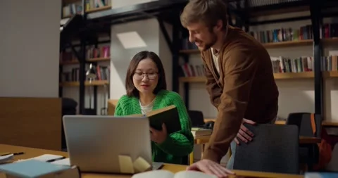 Cheerful conversation between two students while solving a problem and Stock Footage 313356500