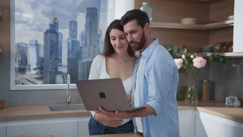 Cheerful couple of affectionate parents using laptop computer searching online Video stock 166165207