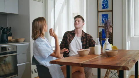 Cheerful couple having fun during home breakfast. Happy man playing with food Stock-Footage 333133459