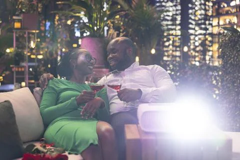 Cheerful couple having fun during entertaining movie night on rooftop terrace Fotos Stock