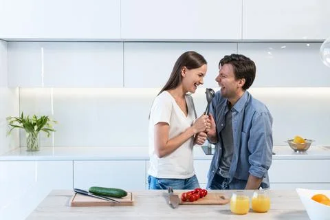 Cheerful couple having fun in the kitchen Stock Photos