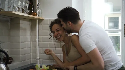 Cheerful couple hugging flirting in kitchen having romantic relationship Sbbd Stock Footage 128285607