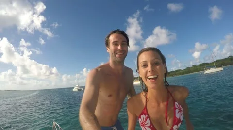 Cheerful couple jumping from boat into caribbean sea Stock Footage 59166470