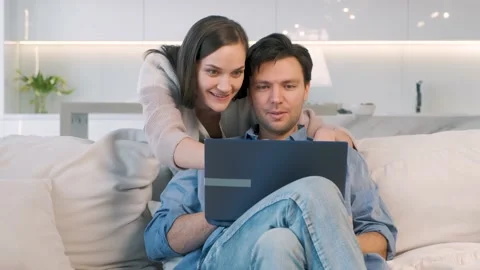 Cheerful couple looking at screen of laptop Stock Footage 149128359