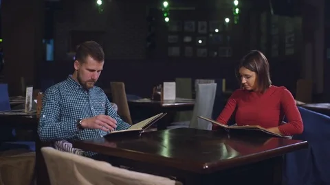 Cheerful couple with menu in a restaurant Stock Footage 70441623