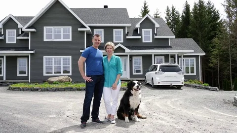 Cheerful couple standing in front of new house Stock-Footage 80315596