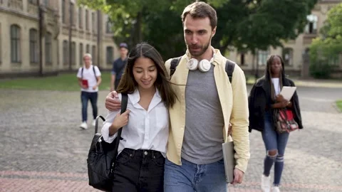 Cheerful couple of students talking during walk Stock-Footage 163282893