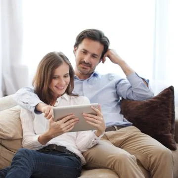 Cheerful couple using tablet Stock Photos