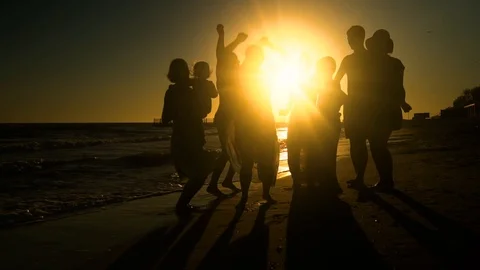 Cheerful crowd dancing on the beach. They jump in the sun. People are having fun Stock Footage 98773391