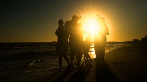 Cheerful crowd dancing on the beach. They jump in the sun. People are having fun Stock Footage 98953162