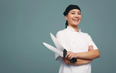 Cheerful culinary chef smiling while holding two knives Stock Photos