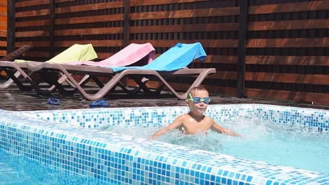 Cheerful cute white kid learning to swim in pool during beach summer vacations. Stock Footage 122224607