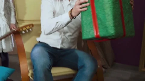 Cheerful dad making large present for his daughter embracing young child Stock Footage 151689471