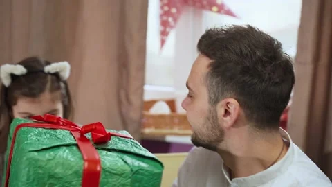 Cheerful dad making large present for his daughter embracing young child Stock Footage 151689481