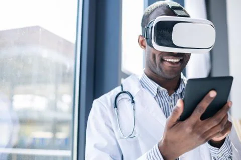 Cheerful dark-skinned man using modern equipment Stock Photos