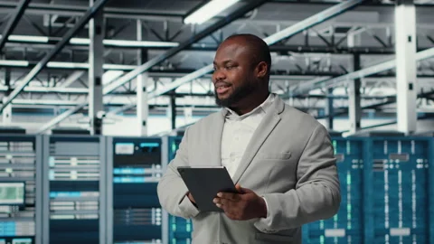 Cheerful data center programmer looking at code debugging tools on tablet Stock-Footage 311897173
