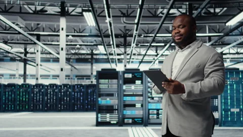 Cheerful data center programmer looking at code debugging tools on tablet Stock Footage 311897541