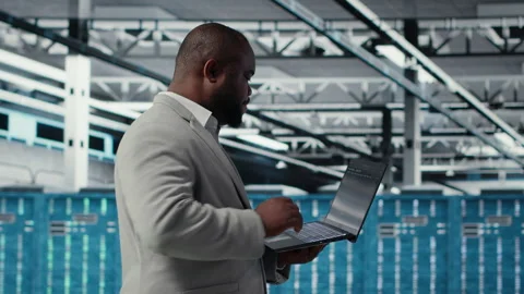 Cheerful data center system administrator reviews code for automation scripts Stock Footage 311832713