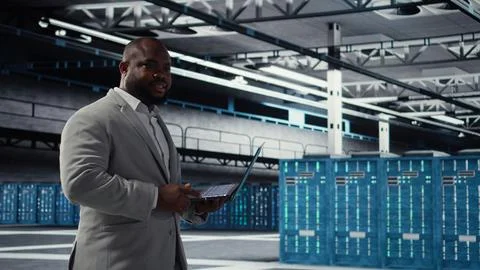 Cheerful data center system administrator reviews code for automation scripts Foto stock