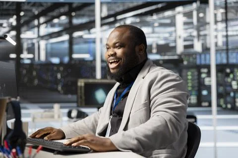 Cheerful developer in data center pleased by stable performance indicators Stockfoto's