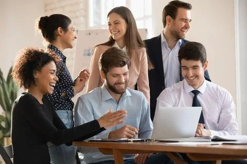 Cheerful diverse coworkers enjoying teamwork success, successful cooperation Stock Photos