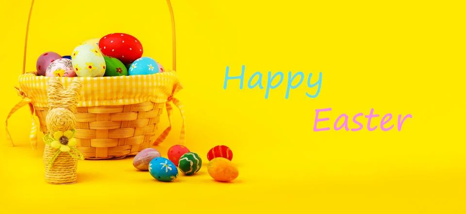 A cheerful Easter banner featuring a wicker basket filled with hand-painted.. Stock Photos