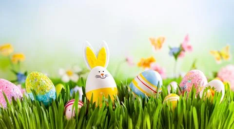 Cheerful Easter scene featuring painted eggs and a cute bunny decoration hi.. Stock Photos