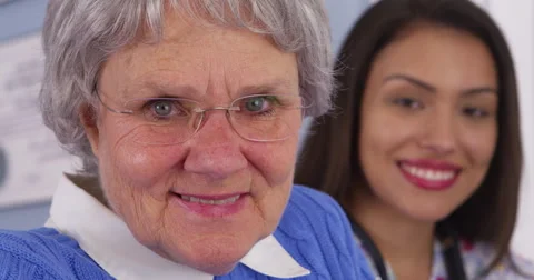 Cheerful elderly patient smiling with Mexican caregiver Video stock 44487219