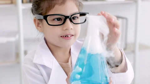 Cheerful elementary kid in the laboratory with white coat uniform and scien.. Vídeo Stock 243622574