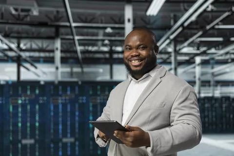 Cheerful engineer in data center updating systems using tablet 写真素材