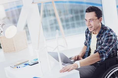Cheerful engineer examining windmills model Foto stock