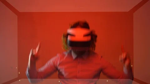 Cheerful engineer having fun in red illuminated room testing virtual reality Stock Footage 125532238