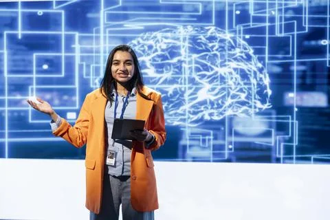 Cheerful engineer holding presentation at AI tech summit using tablet Stock Photos