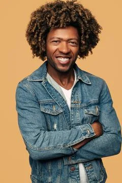 Cheerful ethnic man smiling while standing with crossed arms Stock Photos
